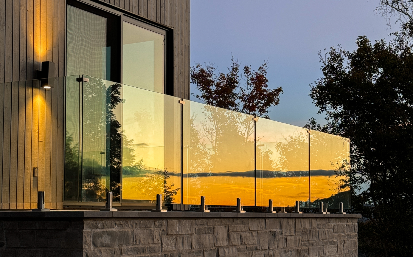 Rampe en verre installée sur un balcon au coucher du soleil